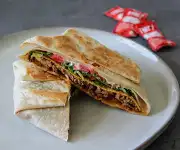 Taco Bell Supreme Taco with seasoned beef, lettuce, tomatoes, cheese and sour cream